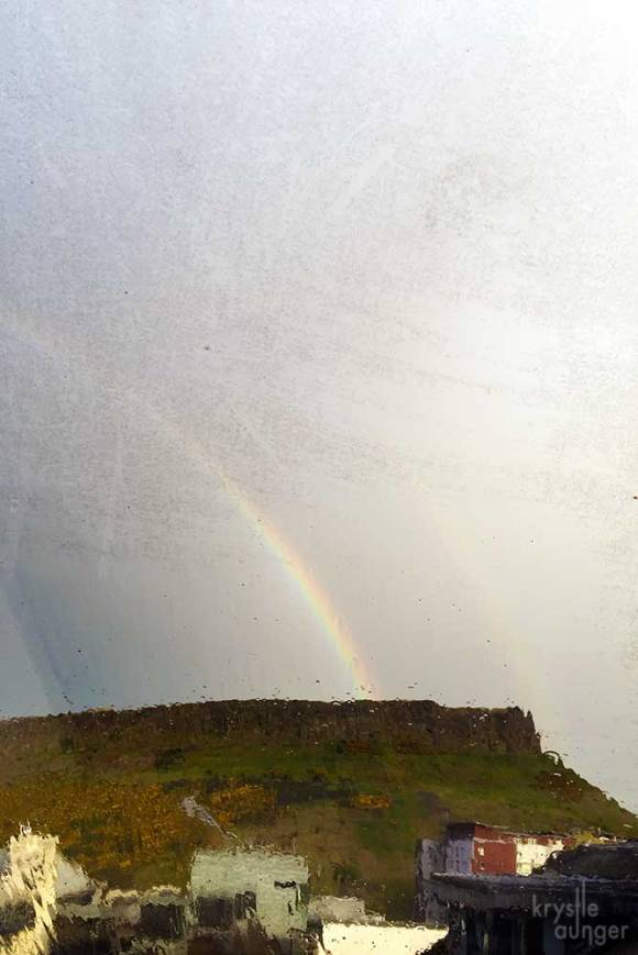 A double rainbow over Salisbury Crags as seen through our flat window.